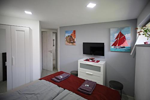 a bedroom with a bed and a tv on the wall at művészház apARTman in Balatonfüred