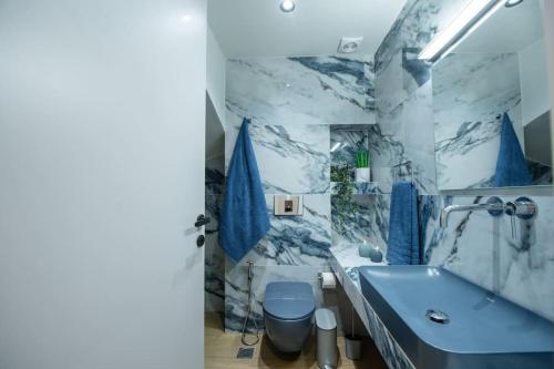 a bathroom with a blue toilet and a sink at Santa Marina Luxury Apartments #1 with pool in Asgourou