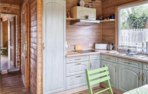 a kitchen with white cabinets and a green chair at Awesome Home In Burg Bei Magdeburg in Burg bei Magdeburg