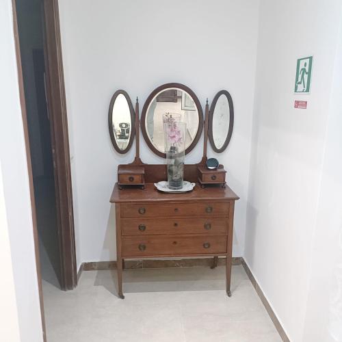 a wooden dresser with three mirrors on top of it at The Pope At The Window in Rome