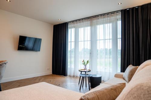 a living room with a couch and a large window at Herberg de Boelekeerl in Halle