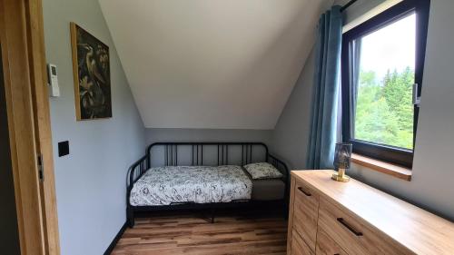 a small bedroom with a bed and a window at Mazurskie Wzgórze Nad Jeziorem Isąg in Pelnik