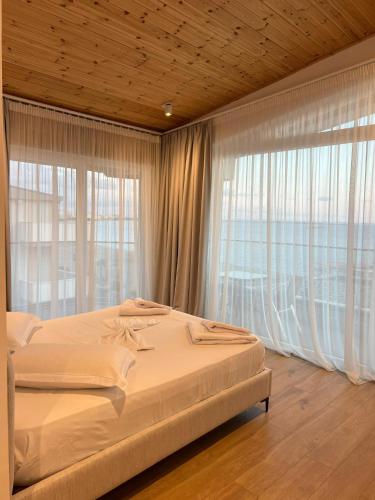 a bedroom with a bed and a large window at Trevi Hotel & Restorant, Shengjin in Shëngjin