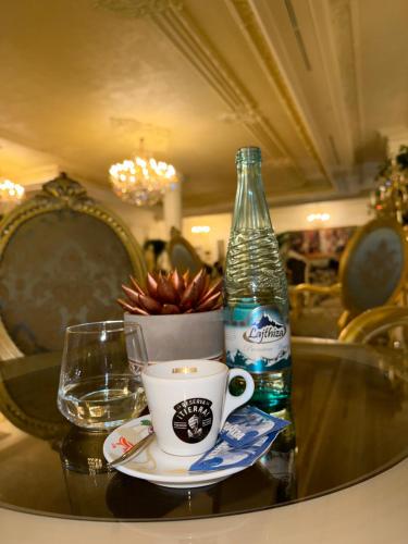 a bottle of water and a cup on a table at King & Queen Boutique Hotel in Fier