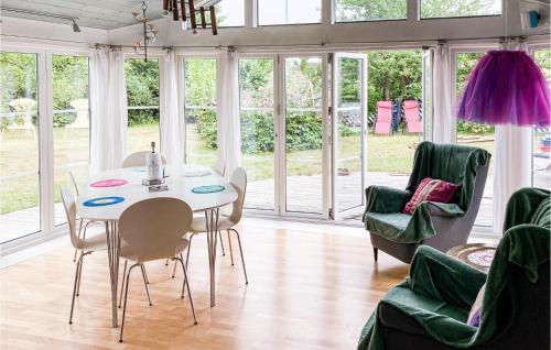 イースタッドにあるCozy Home In Ystad With Kitchenの白いテーブルと椅子のあるダイニングルーム
