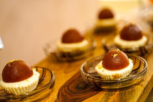 a group of cupcakes in glass bowls on a table at Hotel Mayura in Raipur