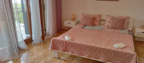 a bedroom with a bed with a pink bedspread at Apartment Oja in Malinska