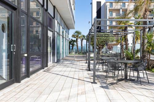 a patio with tables and chairs outside of a building at B&B Hotel Savona in Savona