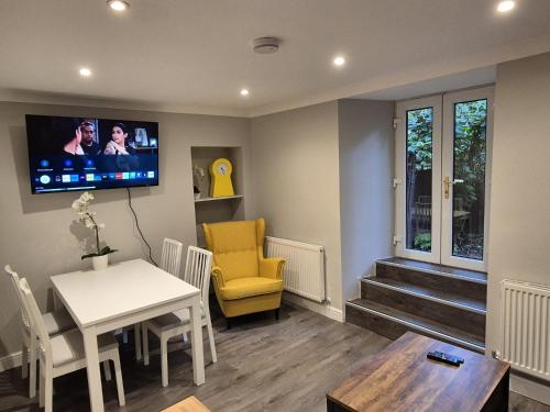 a living room with a table and a tv on the wall at St Patrick Square Main Door in Edinburgh