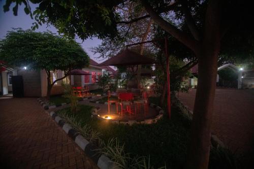 a patio with red tables and chairs at night at Randa Cottages Moshi in Kirua