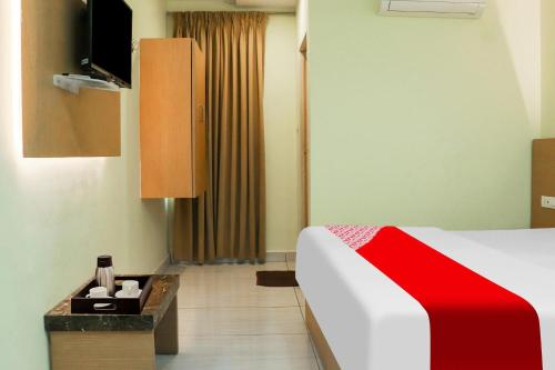 a hotel room with a bed and a television at Collection O Sri Subhamastu Grand in Vijayawada