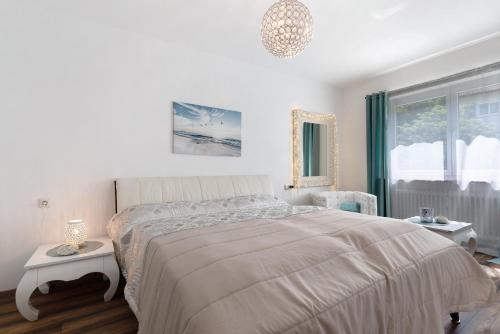 a white bedroom with a large bed and a window at Lopezan home and living in Hornberg