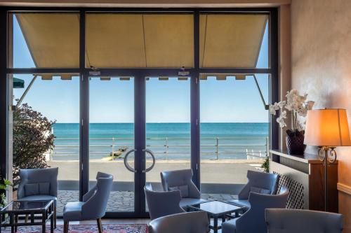 a room with a view of the beach through glass at B&B HOTEL Diano Marina Palace in Diano Marina