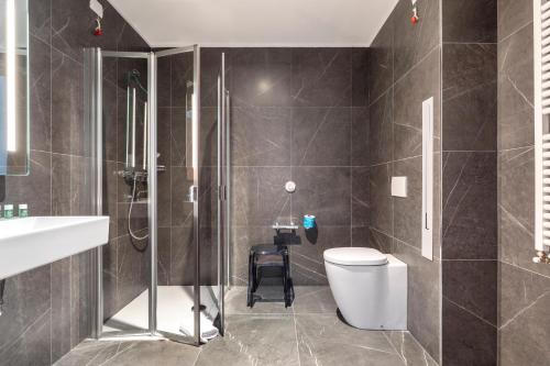 a bathroom with a shower and a toilet and a sink at B&B Hotel Brescia in Brescia