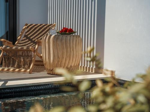 a rocking chair and a bowl of fruit on a porch at Asty Mykonos Hotel & Spa - World of One Hotel Group in Mýkonos City