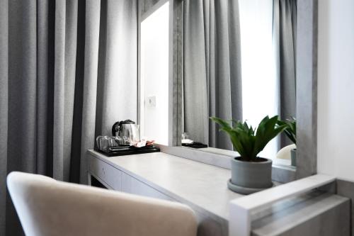 a dressing table with a mirror and a white chair at Naos Luxury Hotel in Vlorë