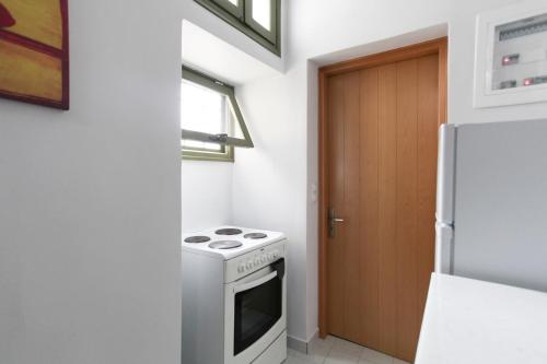 a kitchen with a stove and a refrigerator at La Piccola Casa in Aegina Town
