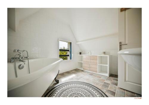 une salle de bain blanche avec une baignoire et un lavabo dans l'établissement Maison sérénité Golf & Piscine !, à Saint-André-des-Eaux