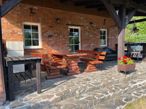a patio with a table and benches on a brick building at Dom pod gwiazdami in Gamerki Wielkie