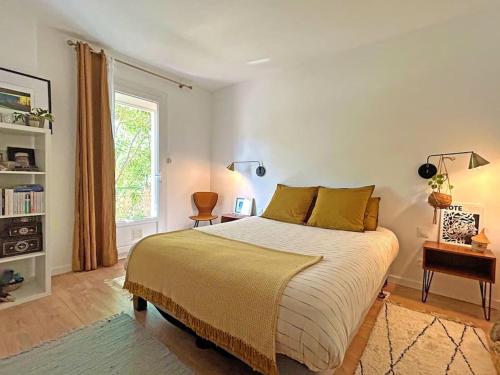 une chambre avec un grand lit et une fenêtre dans l'établissement Charmante maison près du centre-ville et des Calanques, à Marseille