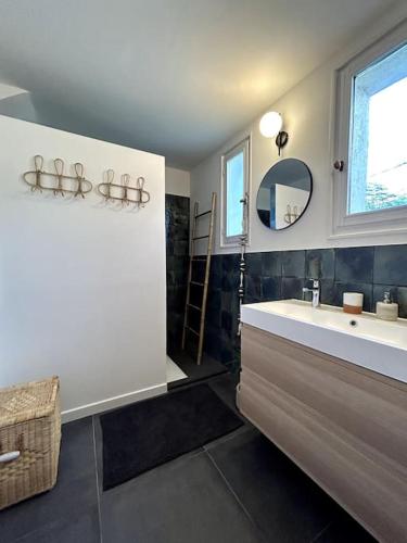 une salle de bain avec une baignoire, un lavabo et un miroir dans l'établissement Charmante maison près du centre-ville et des Calanques, à Marseille