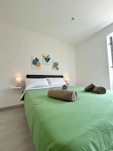 - un grand lit vert avec 2 oreillers dans l'établissement Residence Zar 7, à Trieste
