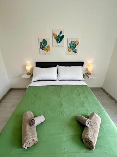 a bedroom with a green bed with towels on it at Residence Zar 7 in Trieste