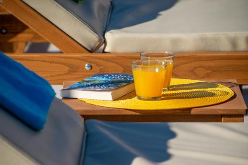 a glass of orange juice and a book on a table at Villa Macanovi dvori with private pool in Knežević