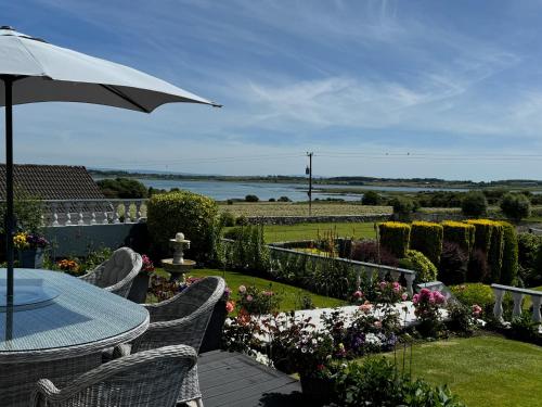 a patio with an umbrella and a table and chairs at Seacrest B&B in Galway
