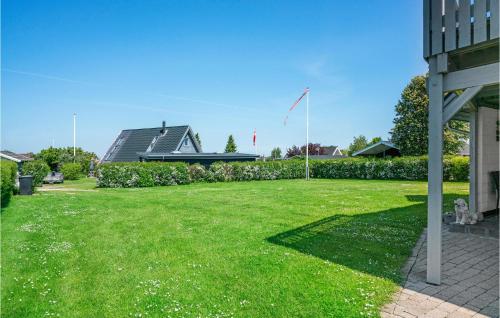a yard with a house and a flag in the grass at Holiday Home Strandvænget Bogense Denm in Bogense