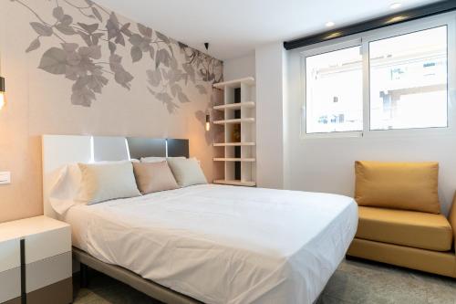 ein Schlafzimmer mit einem großen weißen Bett und einem Fenster in der Unterkunft rentafive - Luxury - Reformado - 2 min Gran Playa in Santa Pola