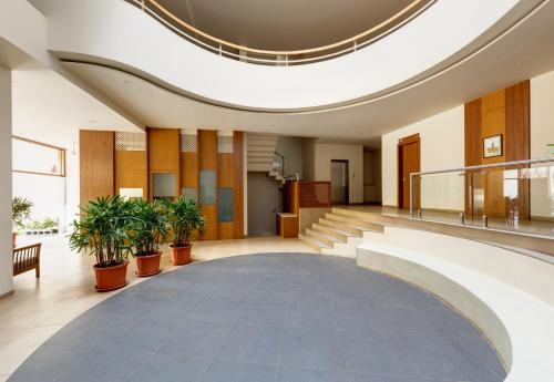 a lobby with potted plants in a building at Hotel Classic Mid Town, Kolhapur NEAR MAHALAXMI TEMPLE in Kolhapur