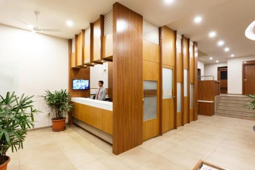 a lobby of an office building with a man in the counter at Hotel Classic Mid Town, Kolhapur NEAR MAHALAXMI TEMPLE in Kolhapur