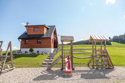 a playground in front of a building with a house at Chaty Snowflakes v Snowpark Lučivná in Lučivná