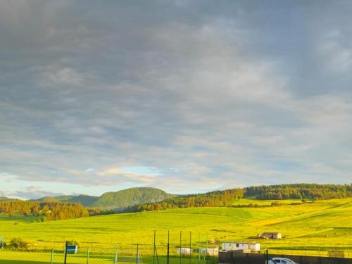 a field of green grass with mountains in the background at Turistická ubytovňa Hornád in Spišské Tomášovce