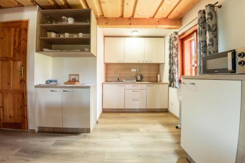 a kitchen with white cabinets and a refrigerator at Chaty Snowflakes v Snowpark Lučivná in Lučivná