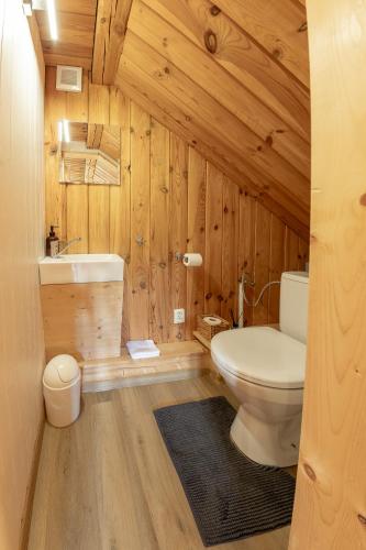 a wooden bathroom with a toilet and a sink at Chaty Snowflakes v Snowpark Lučivná in Lučivná