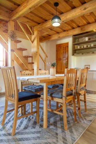 a dining room with a wooden table and chairs at Chaty Snowflakes v Snowpark Lučivná in Lučivná