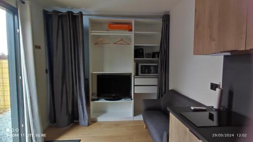 un salon avec un canapé et une télévision dans l'établissement Studio Smarty, à Parigné-lʼÉvêque