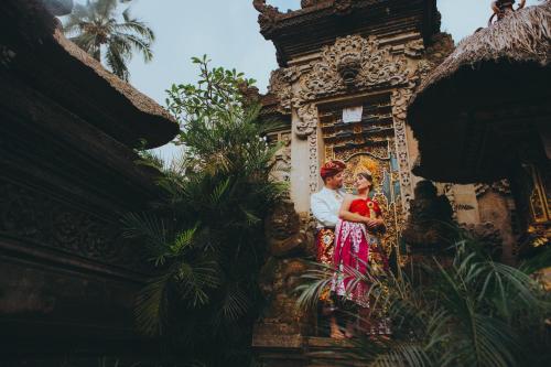 a man and a woman standing in front of a building at De Umah Bali Eco Tradi Home in Bangli