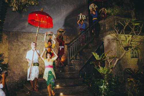 a painting of a group of people walking up the stairs at De Umah Bali Eco Tradi Home in Bangli