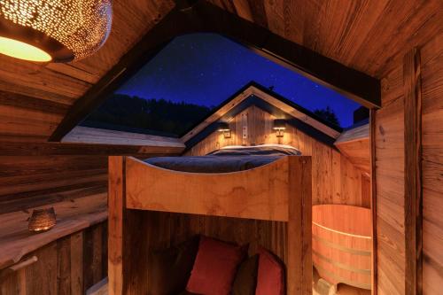 a room with a bed in a cabin with a window at Les Cabanes de Rensiwez in Mabompré