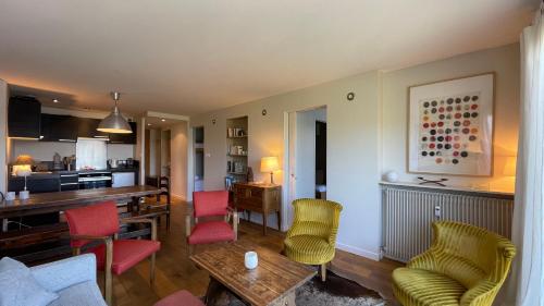 - un salon avec des chaises colorées et une table dans l'établissement Homency - Résidence Belvédère D5, à L'Alpe-d'Huez