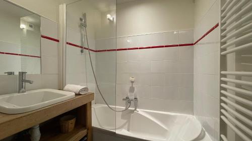 ein weißes Badezimmer mit Waschbecken und Dusche in der Unterkunft Homency - Résidence Belvédère D5 in L'Alpe-d'Huez