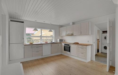 RefshammerにあるCozy Home In Nykøbing M With Wifiの白いキャビネットと窓付きの白いキッチン
