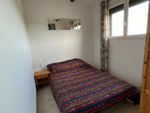 une petite chambre avec un lit et une fenêtre dans l'établissement Appartement T2 Mezzanine Vue mer - 4PVM552, à Saint Pierre La Mer