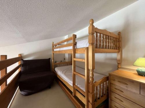 Cette chambre comprend 2 lits superposés et une chaise. dans l'établissement Pavillon à Gruissan, 25m², 4 pers., piscine, parking, proche plage - FR-1-229-115, à Gruissan