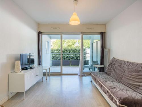 un salon avec un canapé et une télévision dans l'établissement Charmant studio avec terrasse, parking en sous-sol, entre Biarritz et Anglet, à 5 km des plages - FR-1-3-600, à Anglet