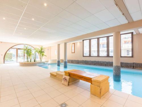 - une piscine avec un banc en bois dans un bâtiment dans l'établissement Duplex 8 Pers Centre-Ville Saint-Lary-Soulan Piscine Hammam Sauna - FR-1-296-489, à Saint-Lary-Soulan