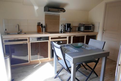 eine Küche mit einem Tisch und einem Tisch und Stühlen in der Unterkunft Hâvre de paix en bord de mer in Lannion